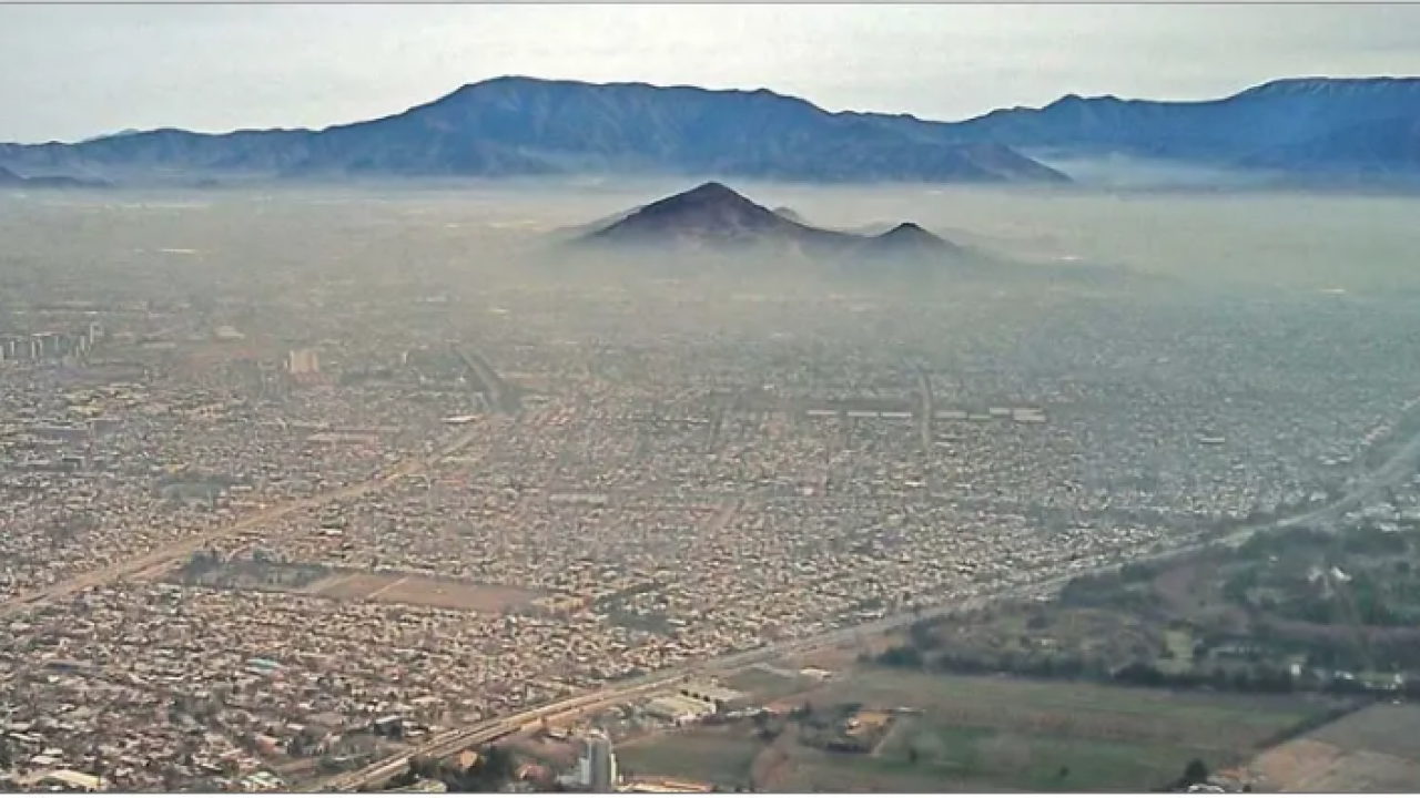 Image: a metropolitan area blanketed by pollution.