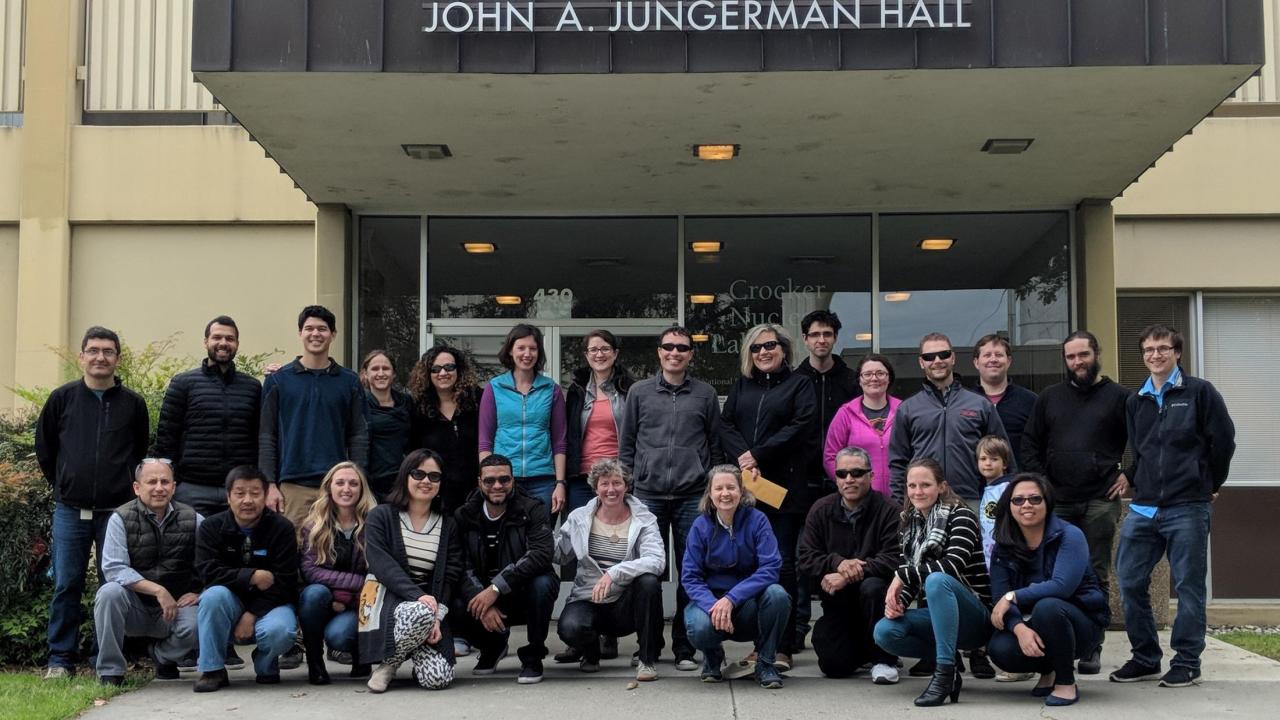 Image: members of the Air Quality Research Center stand in front of a campus building.