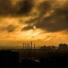 Image: a industrial emissions envelope a metropolitan area at dusk. Image by Free-Image of Pixabay. End ID.