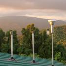 Image: inlet stacks of monitoring station surrounded by forested mountains.