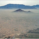 Image: a metropolitan area blanketed by pollution.